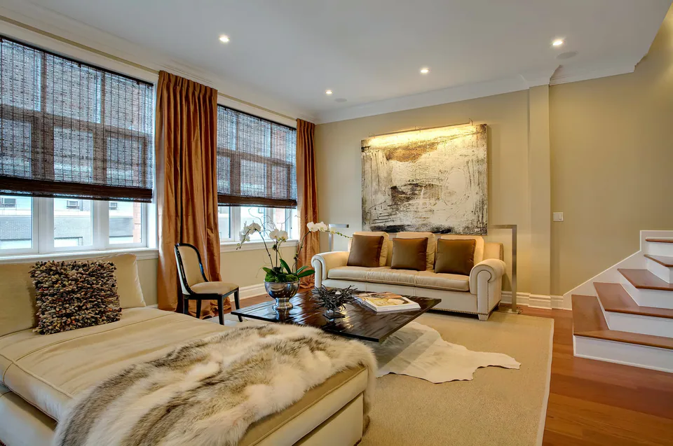 Living room with a fur throw and warm drapery, interior design by Paul Lauren Designs